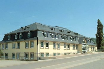 Verwaltungsgebauude in Perl Verwaltungsgebauude in perl mit grauem Dach und vielen Fenstern unter einem klaren Himmel.