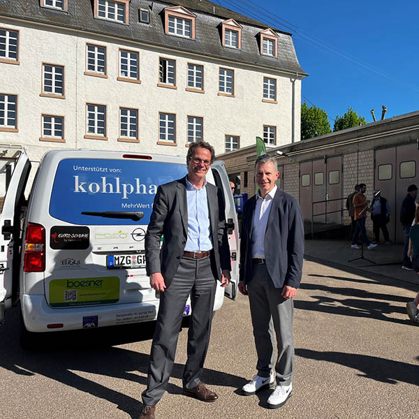 Sponsoring Veranstaltung kohlpharma Zwei Personen stehen vor einem Van mit der Aufschrift kohlpharma und sprechen bei einer Veranstaltung.