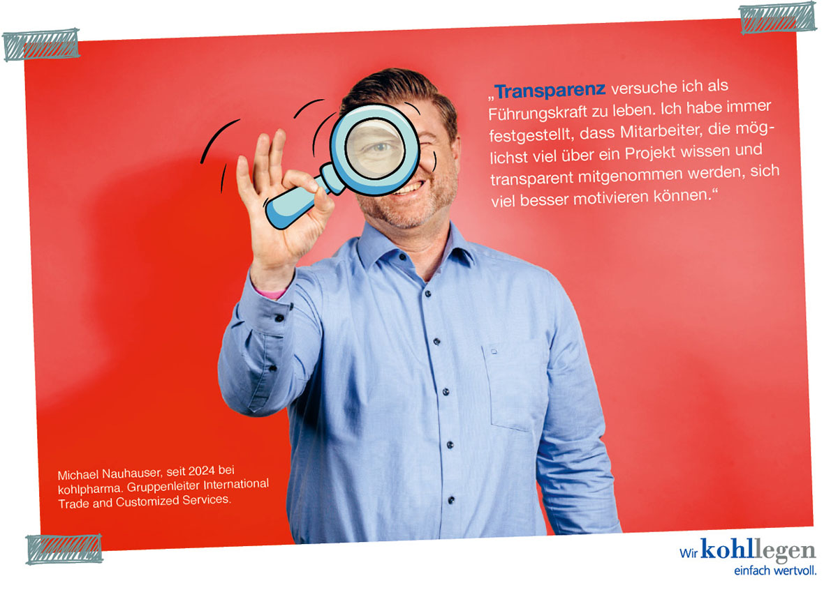 Michael Nauhauser hält eine Lupe vor sein Auge und steht vor einem roten Hintergrund mit Text.